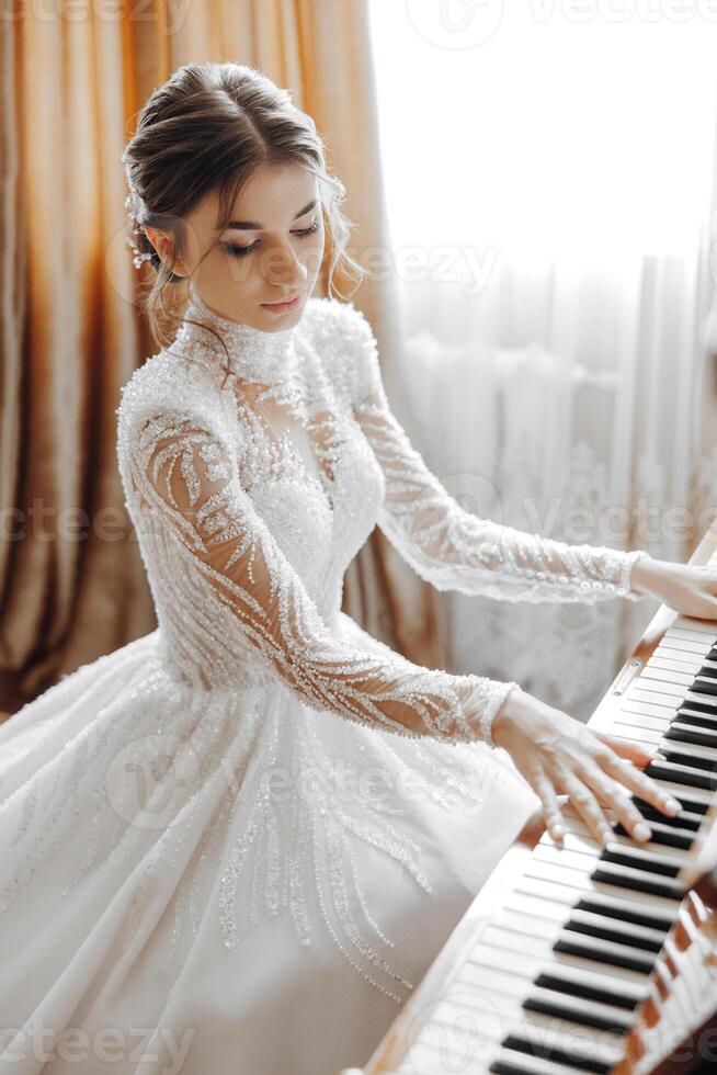 A woman in a wedding dress is playing the piano photo