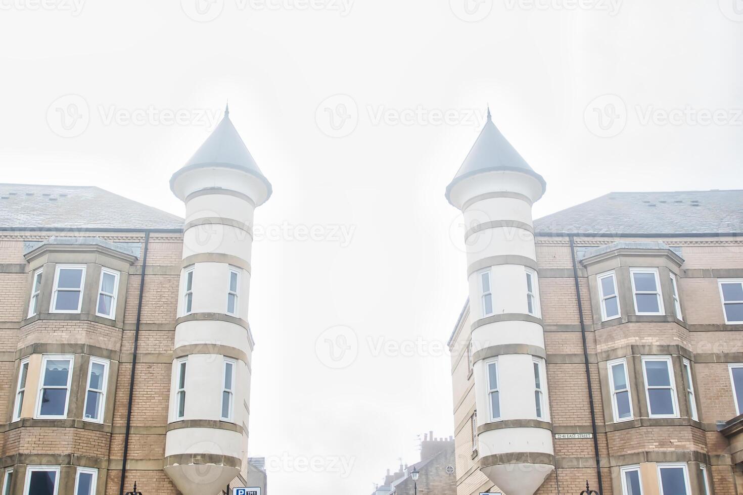 Symmetrical brick buildings with cylindrical towers photo