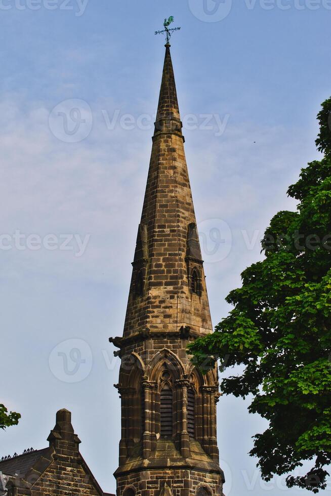 Stone church steeple with weather vane in Harrogate, North Yorkshire photo