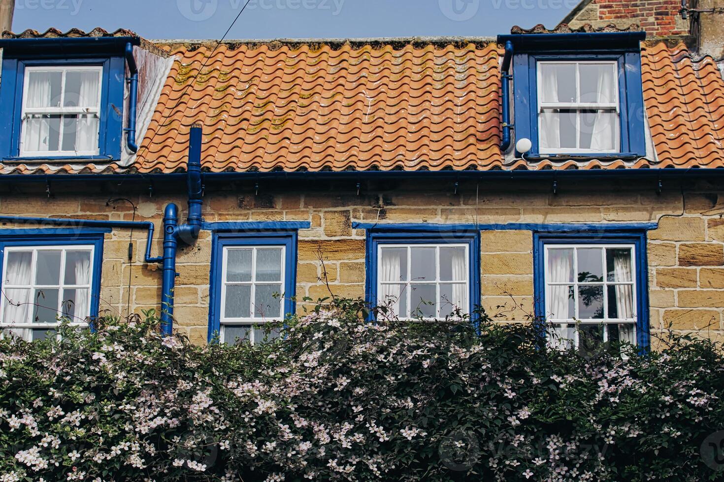 Charming stone house with red tiled roof and blue window frames Robin Hood's Bay, Yorkshire photo