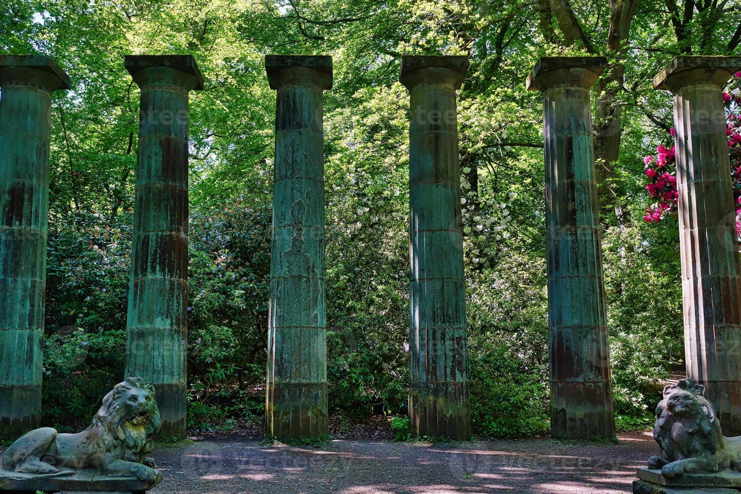 Ancient Stone Columns and Lion Statues in a Park photo