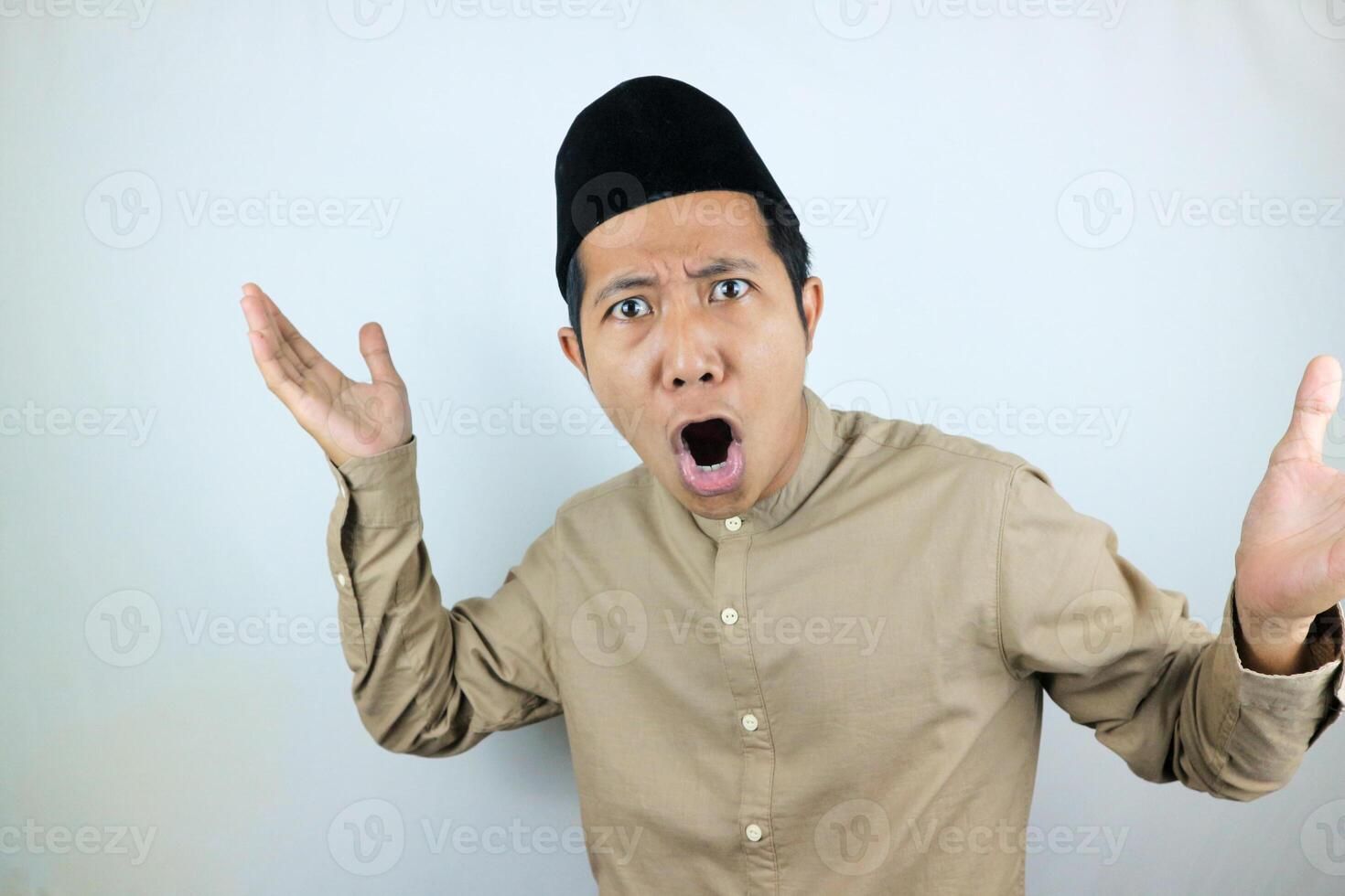 funny facial expression shock and confuse asian muslim men wearing cap isolated on white background photo