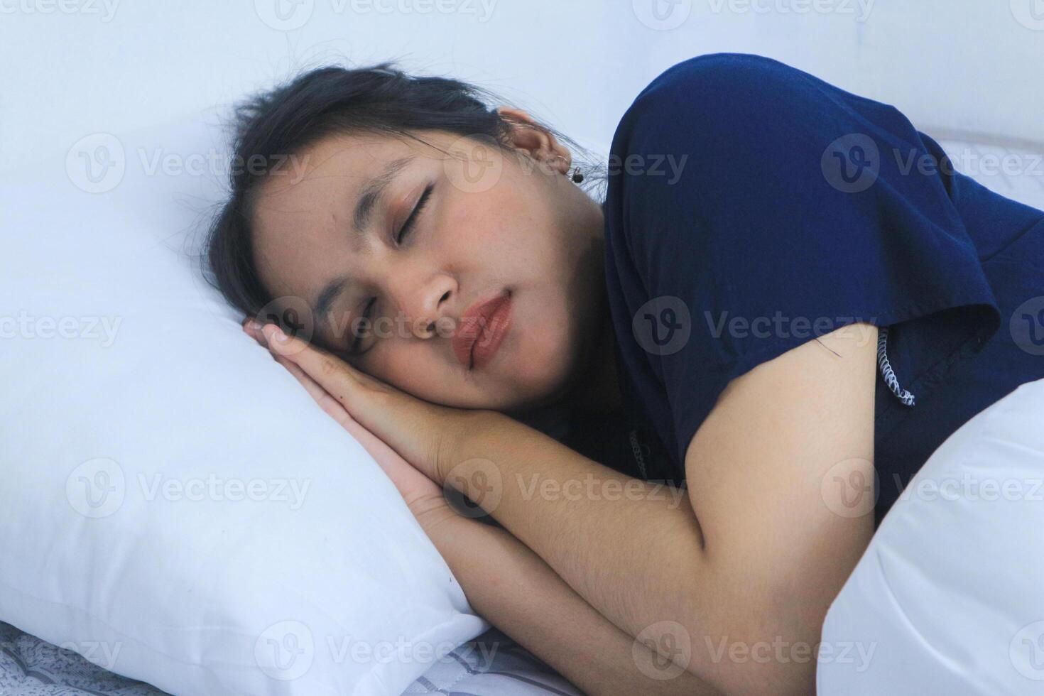 Beautiful Asian woman sleeps comfortably and sweet dreams lying on bed in cozy bedroom photo