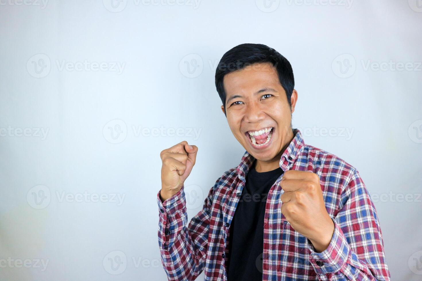 yes, happy expression of asian man clenching his fists. victory concept, isolated white background photo