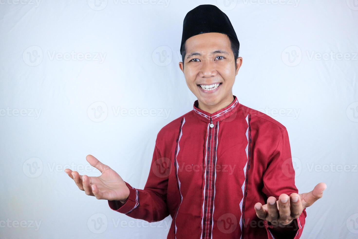 Smiling of excited muslim asian man wearing cap with open hand gesture photo