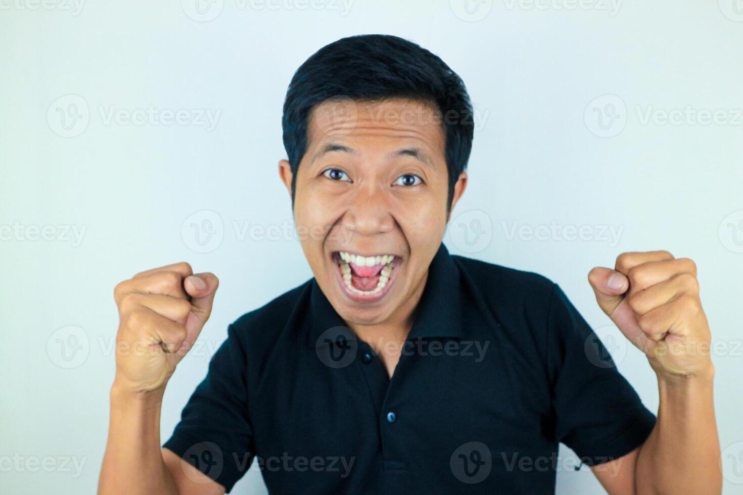 yes, happy expression of asian man clenching his fists. victory concept, isolated white background photo