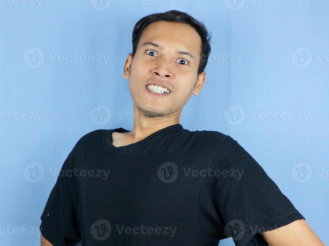 Angry young Asian man expression with pointing gesture and bulging eyes. Mental health concept photo