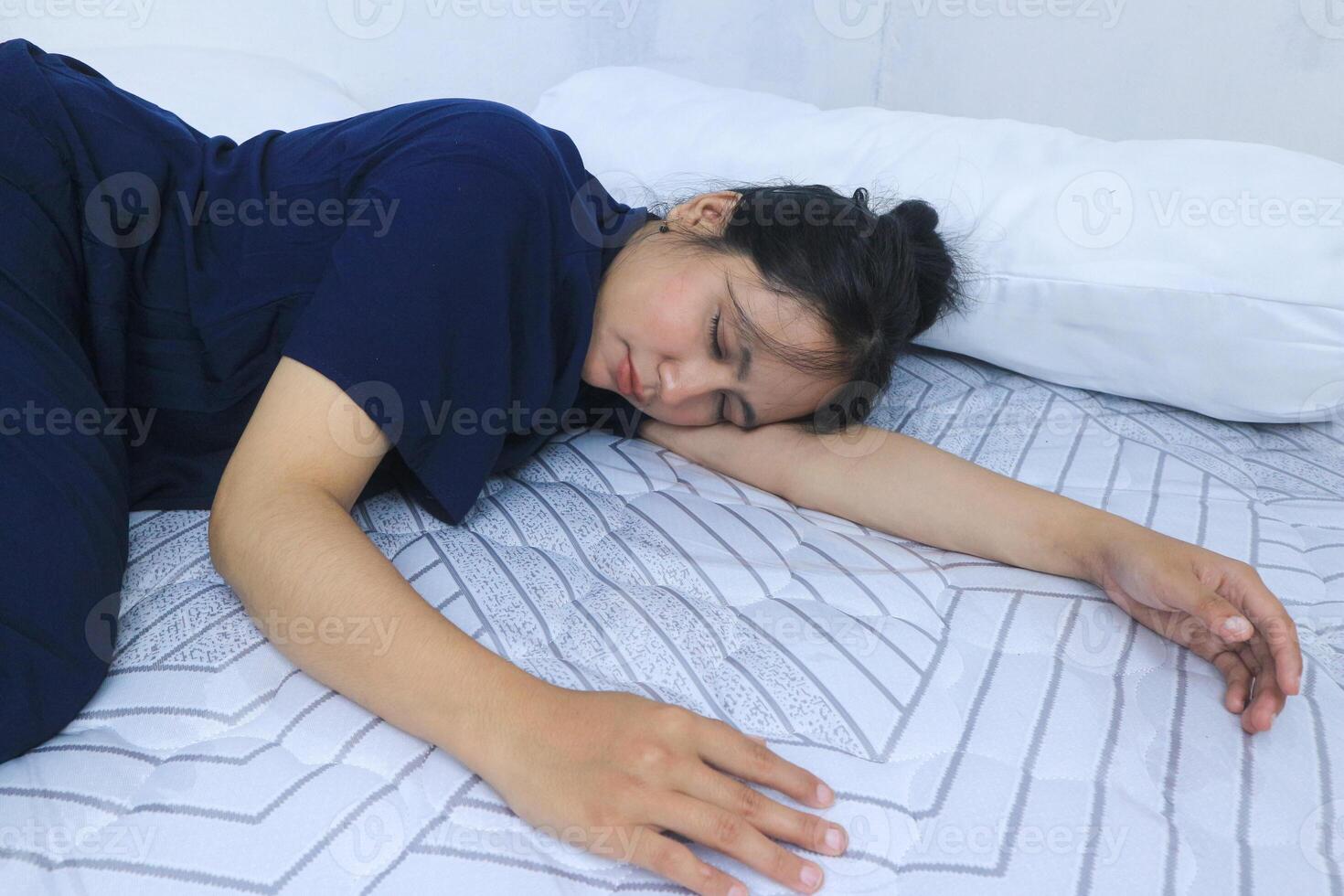 Beautiful Asian woman sleeps comfortably and sweet dreams lying on bed in cozy bedroom photo