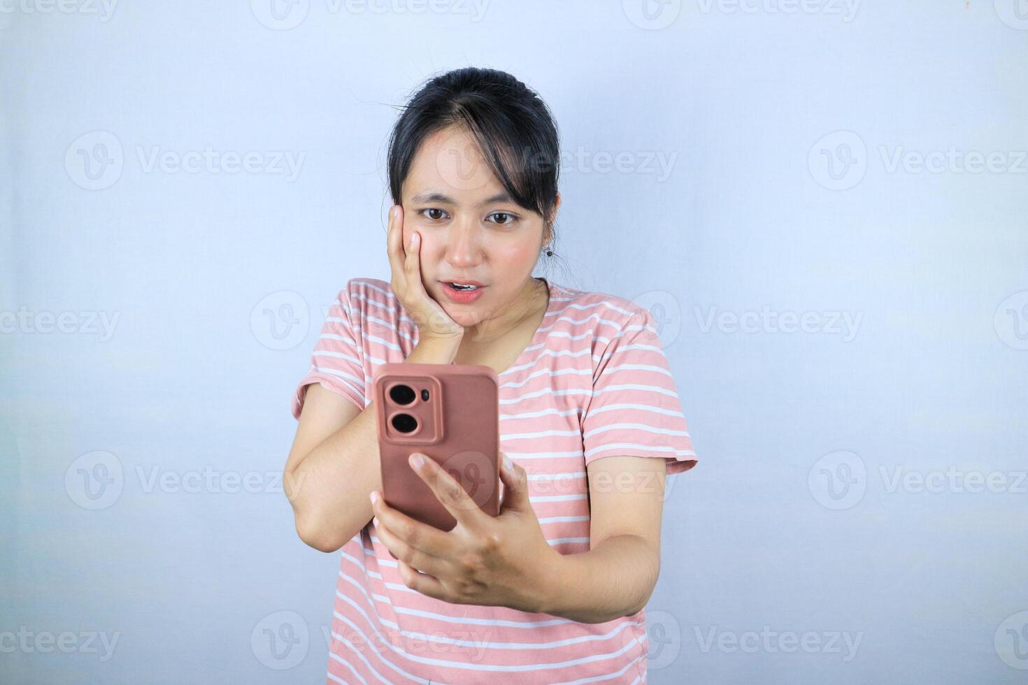 Shocked expression asian woman reading message on smart phone, on white background photo