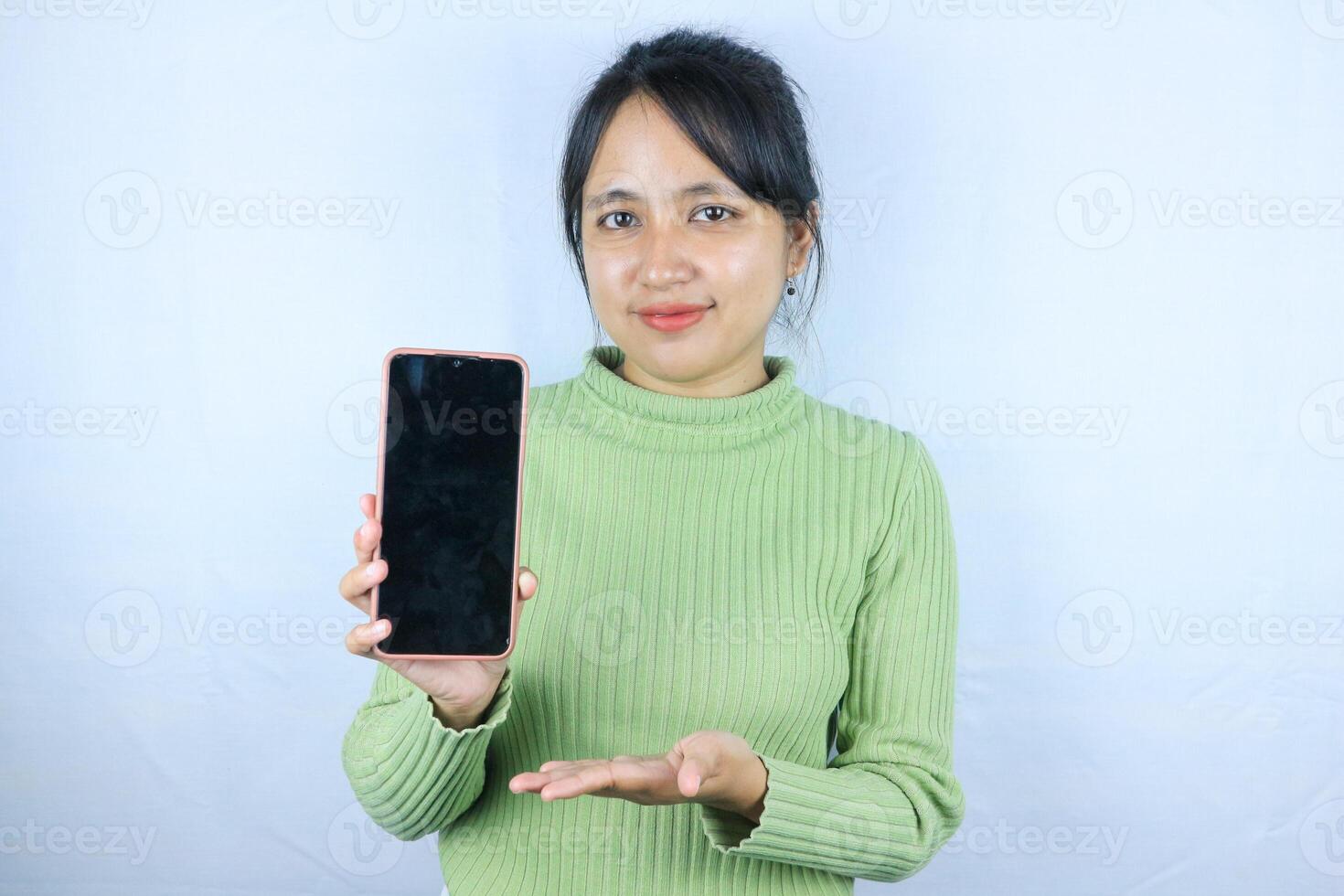 Young beautiful asian woman holding blank screen smart phone on white background photo