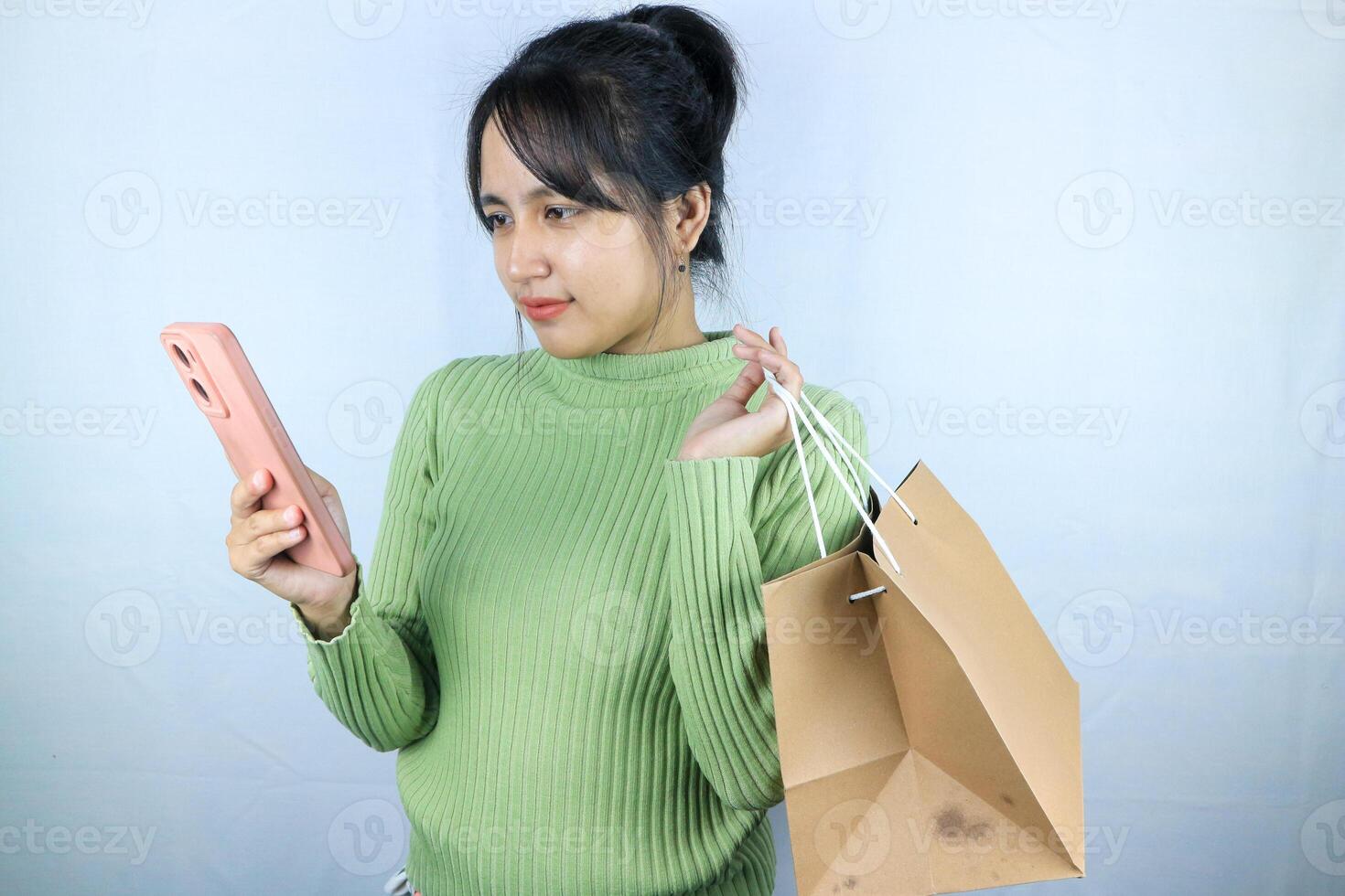 Beautiful Asian young girl holding a brown blank paper bag and makes purchases in an online store photo