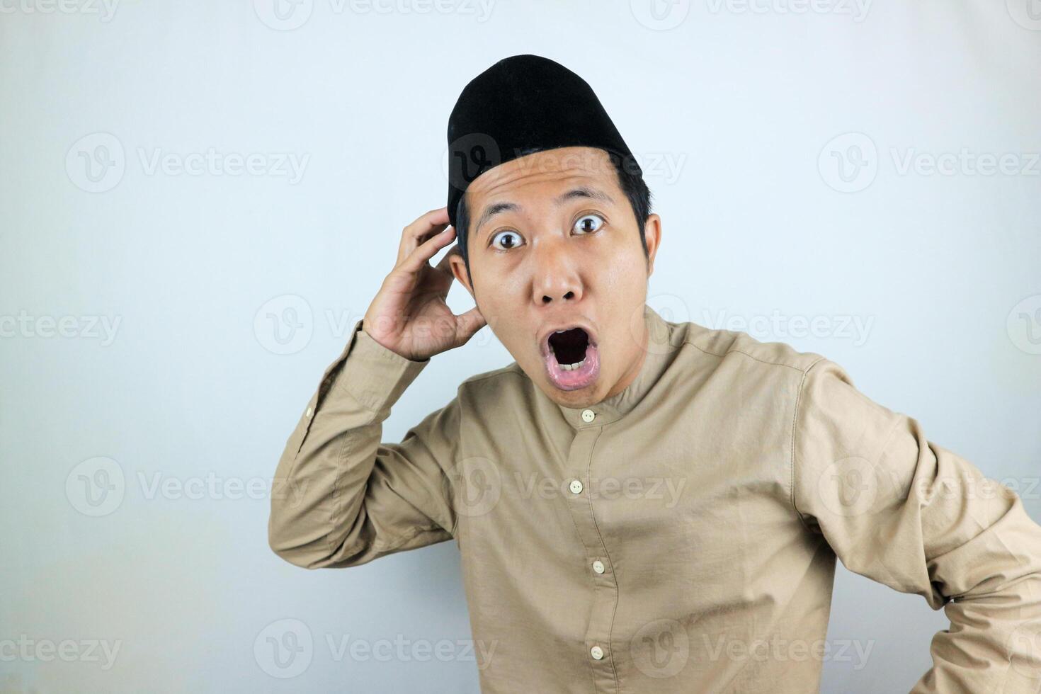 funny shocked and surprise expression asian muslim men wearing cap isolated on white background photo