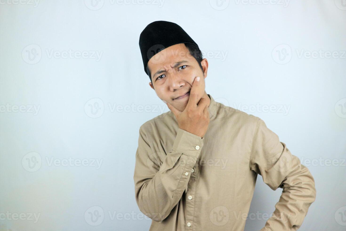 Confuse expression of asian muslim man doing thinking gesture, looking for idea on white background photo