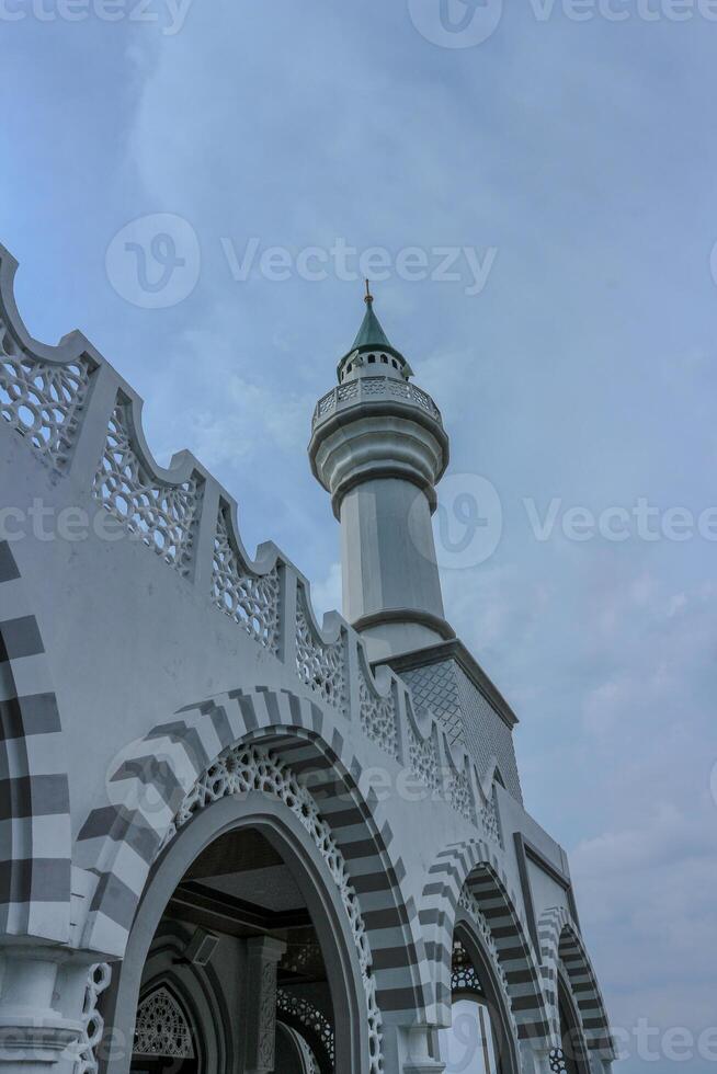 Beautiful white mosque in Ungaran, Indonesia with a blue sky background photo