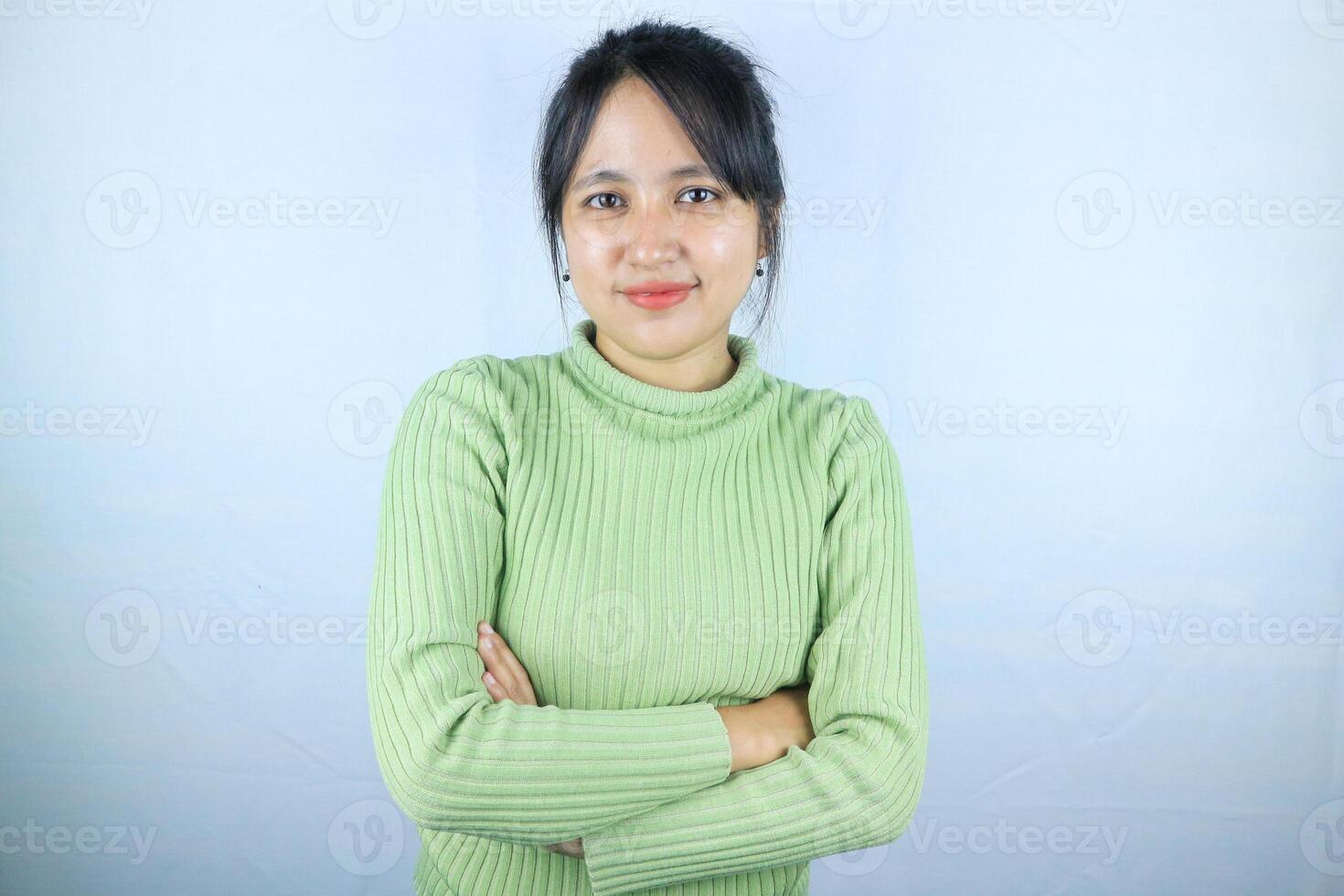 Portrait of a confident smiling Asian woman standing with arms folded and looking at the camera photo