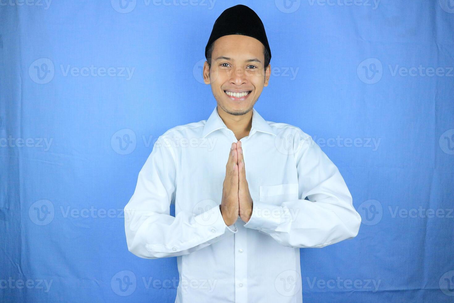 Smiling expression Asian Muslim man greeting Ramadan and Eid Al Fitr celebration on white background photo
