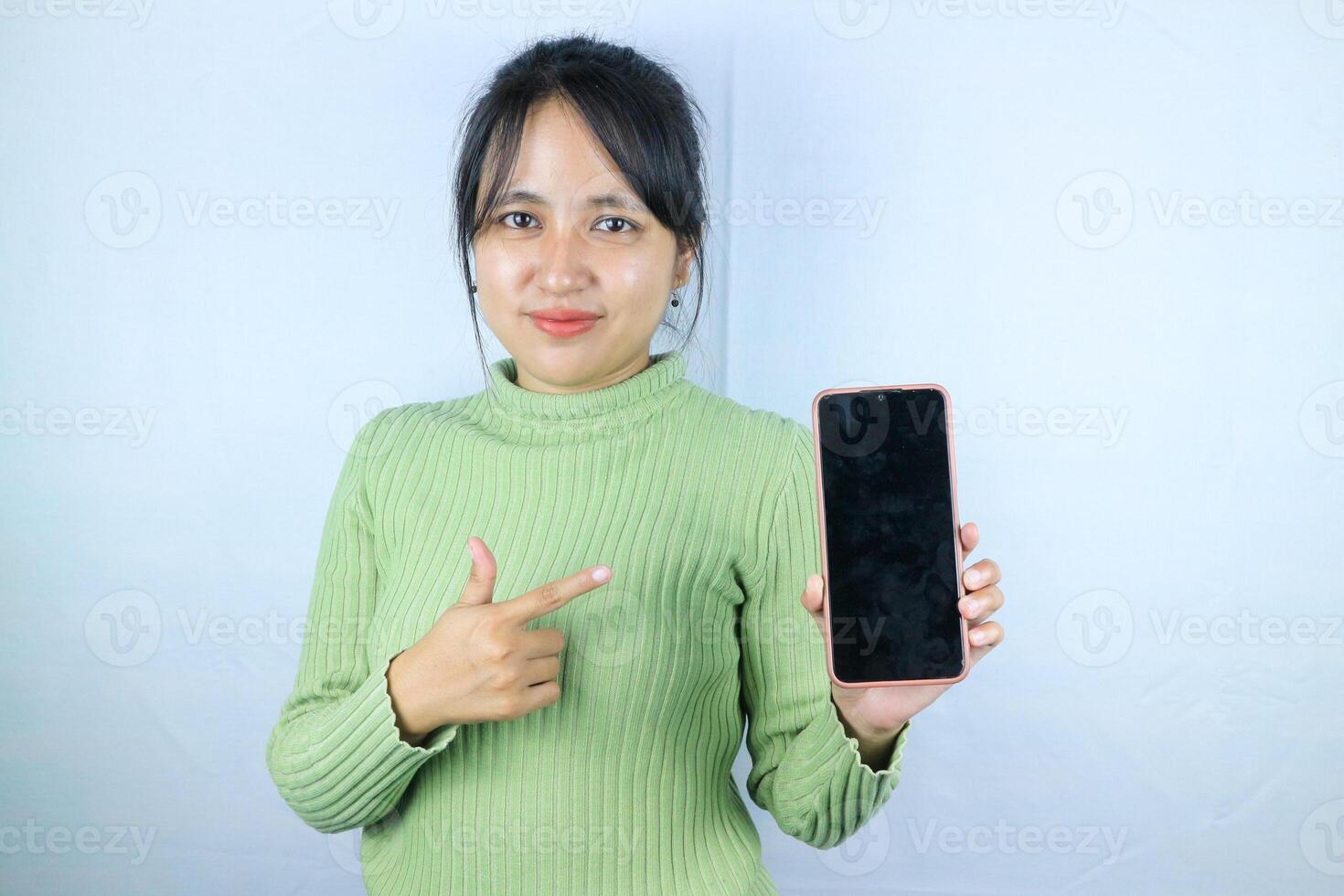 Young beautiful asian woman holding blank screen smart phone on white background photo