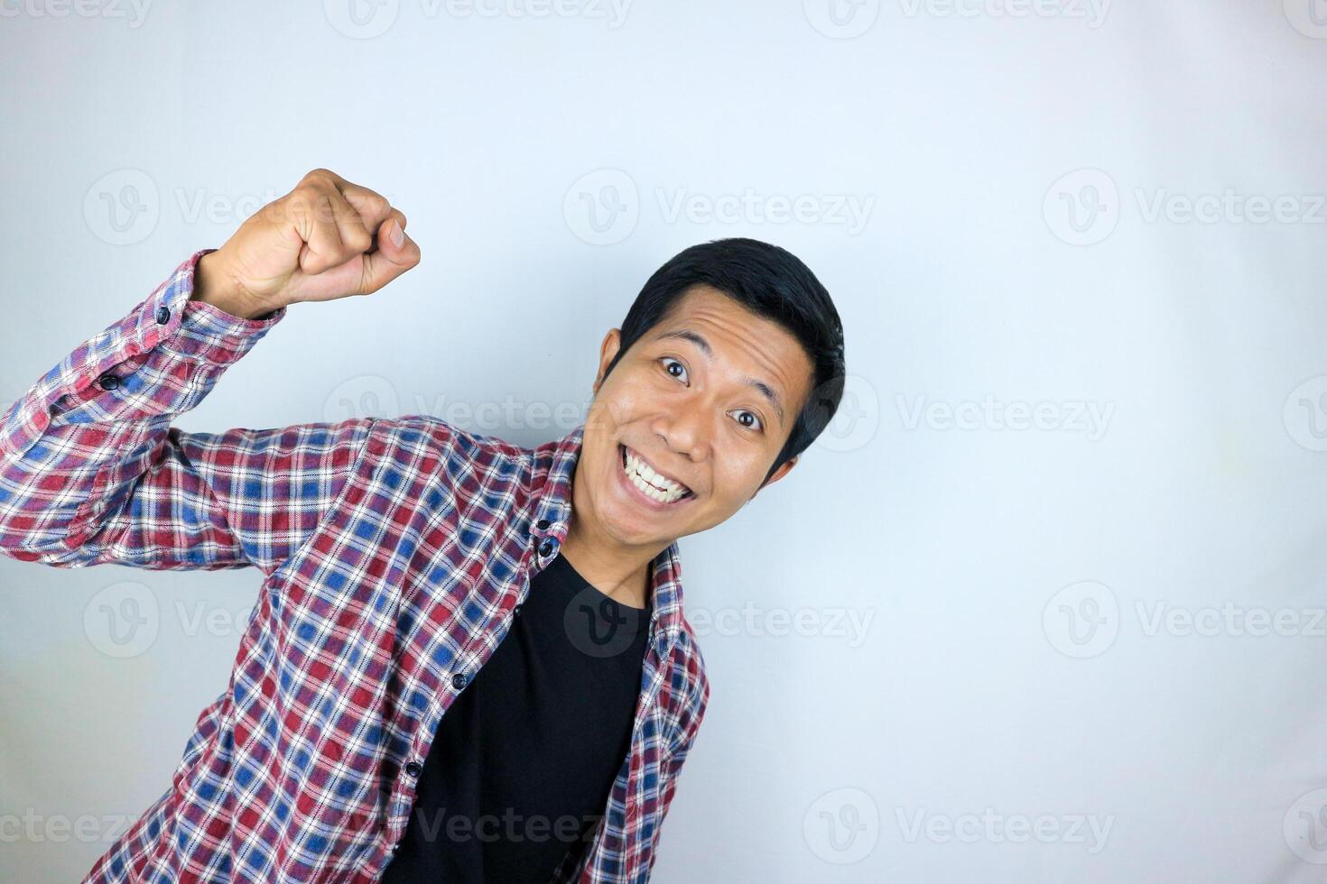 yes, happy expression of asian man clenching his fists. victory concept, isolated white background photo
