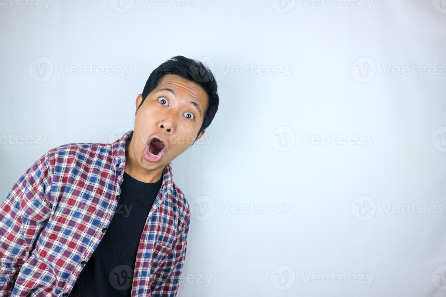 funny expression of shocked and surprised Asian man in flannel shirt isolated on white background photo