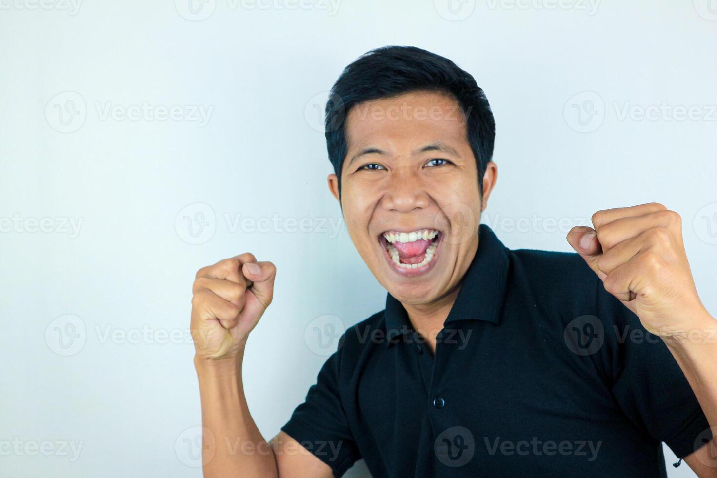 yes, happy expression of asian man clenching his fists. victory concept, isolated white background photo