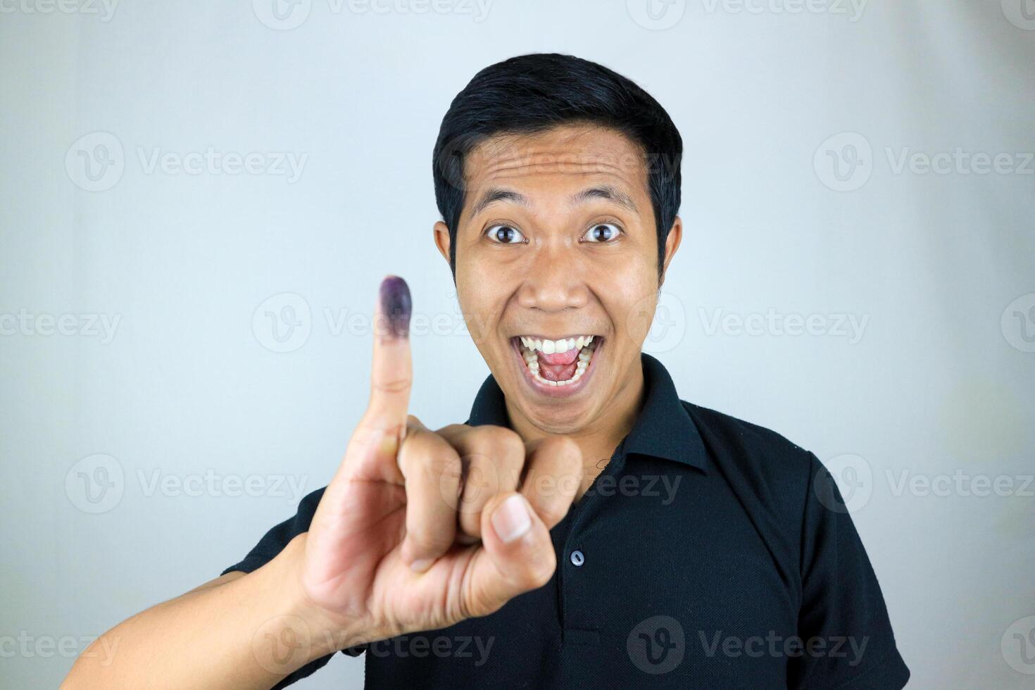 Smiling Indonesian man showing little finger after voting on Indonesia's presidential election photo