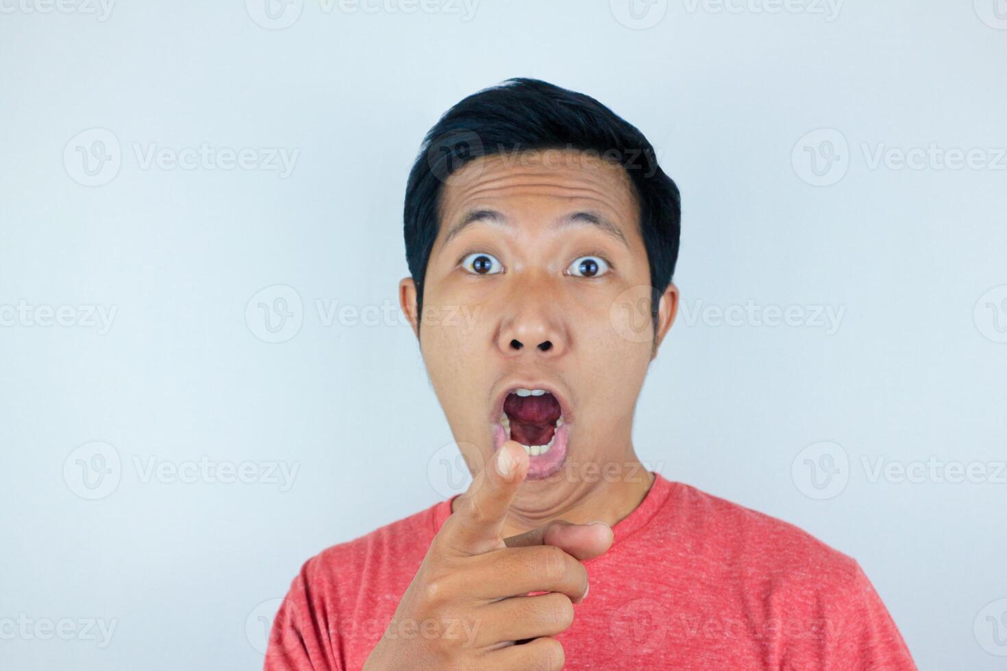 funny facial expression of asian man shocked and surprised while looking and pointing at the camera photo
