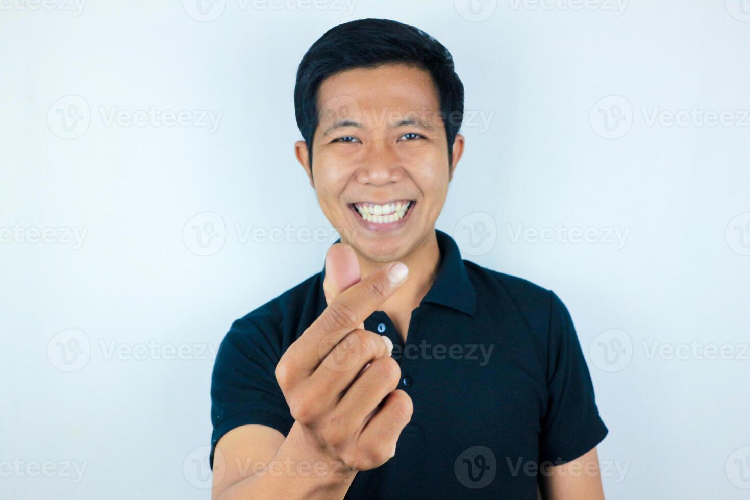 Young asian man isolated on white background smiling and gesturing a heart shape with hands photo