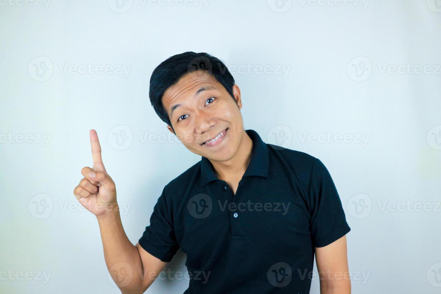 Asian man expression smiling while pointing to the side presenting the product. advertising concept photo