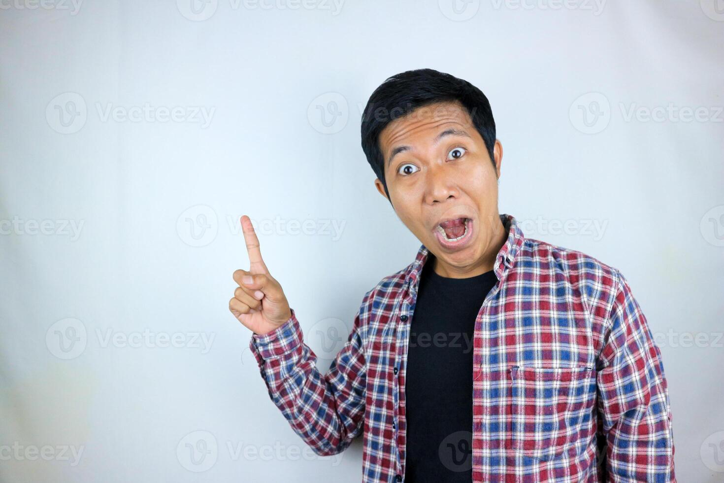 Asian man expression smiling while pointing to the side presenting the product. advertising concept photo