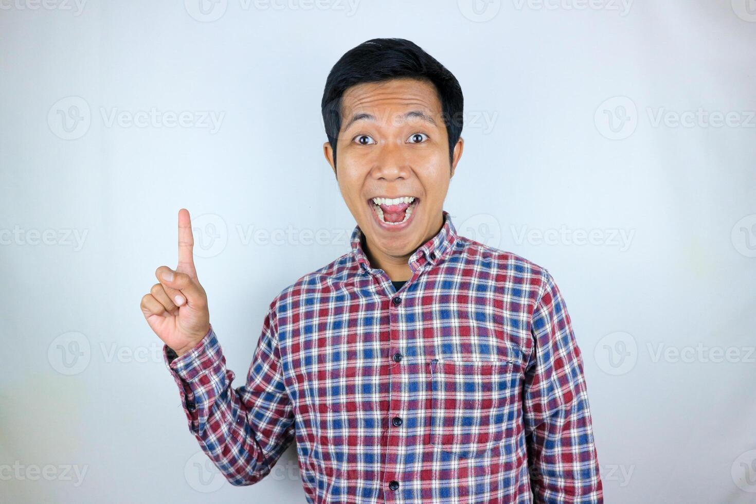 Asian man smiling while pointing up presenting product. advertising concept photo