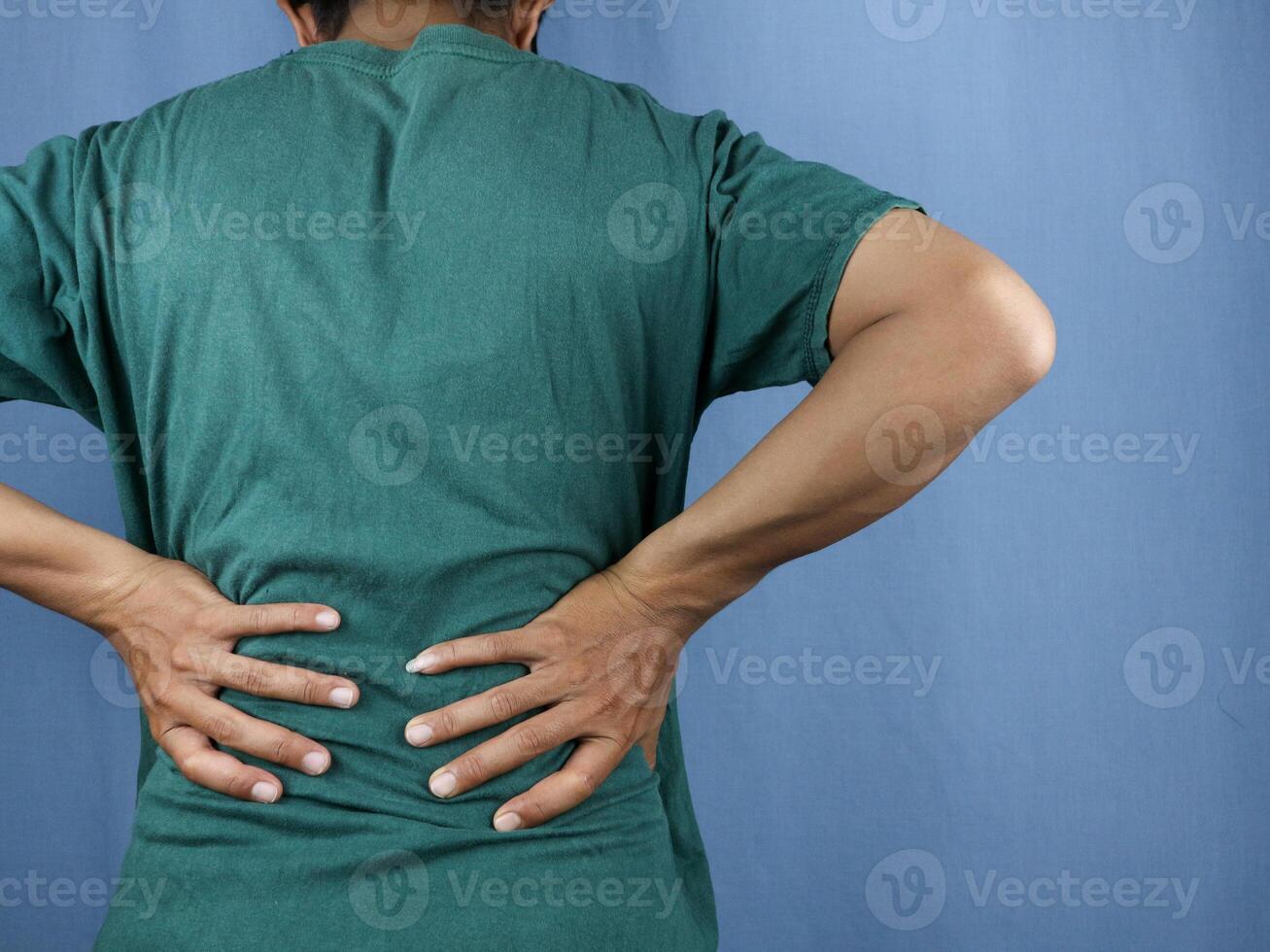Close-up rear view of man's hand touching back pain, low back pain concept. photo