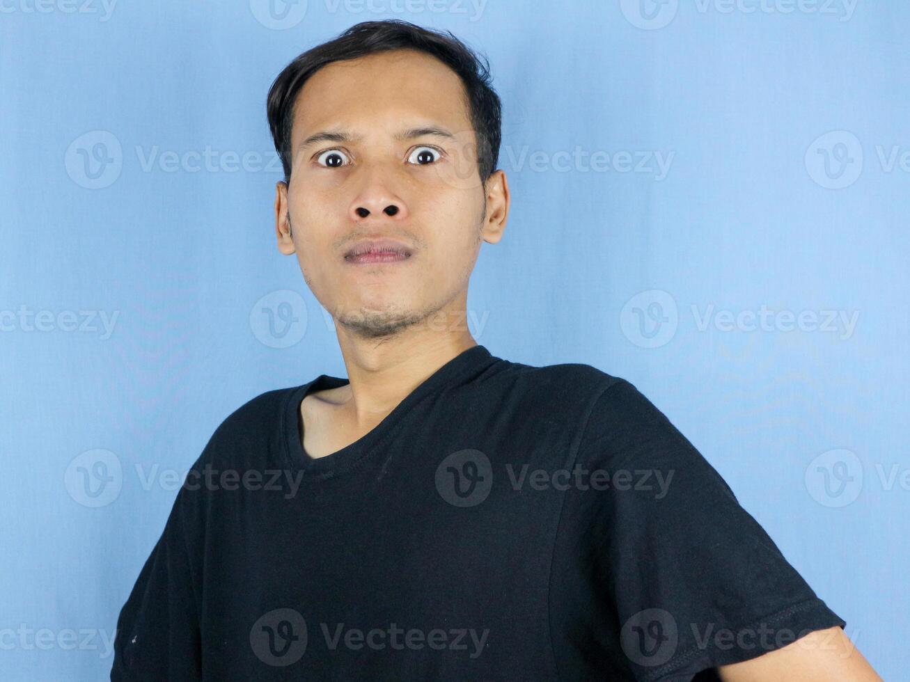 Angry young Asian man expression with pointing gesture and bulging eyes. Mental health concept photo
