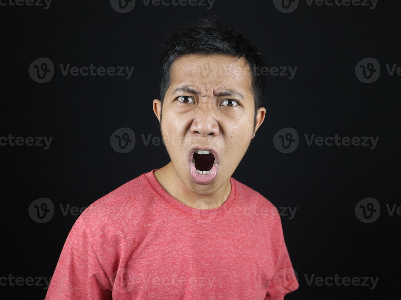 crazy amazed young man open mouth unbelievable information isolated on black background photo