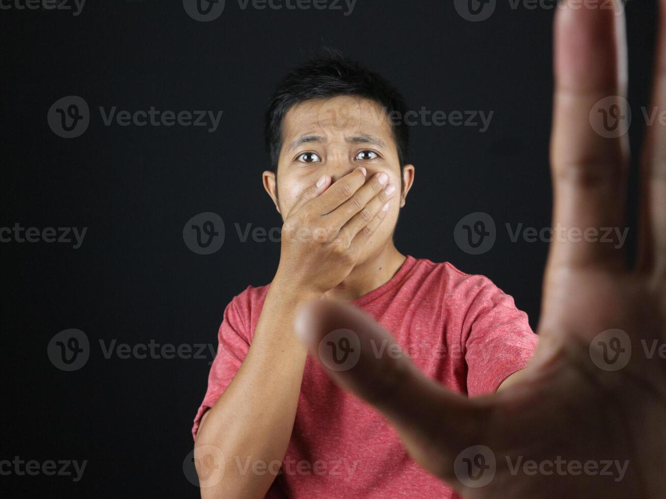 gesture Asian man covering his nose and making stop sign with his hand because of a strong smell. photo