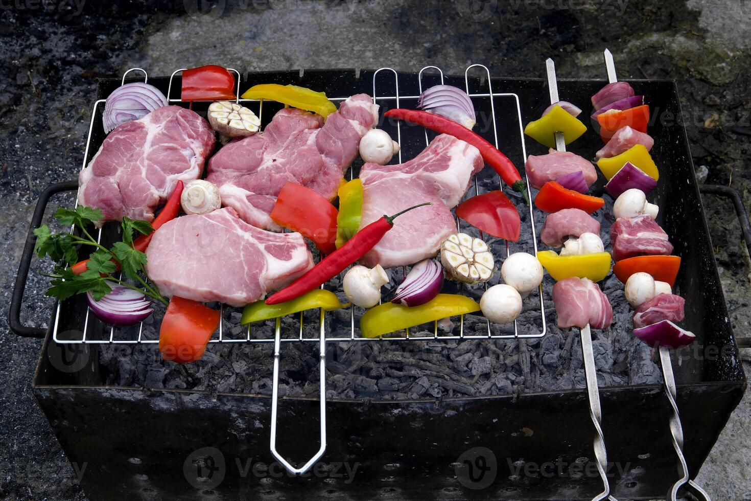 fresh raw beef shish kebab with pepper chunk on black big grill bbq Raw meat skewers with vegetables on wooden background photo