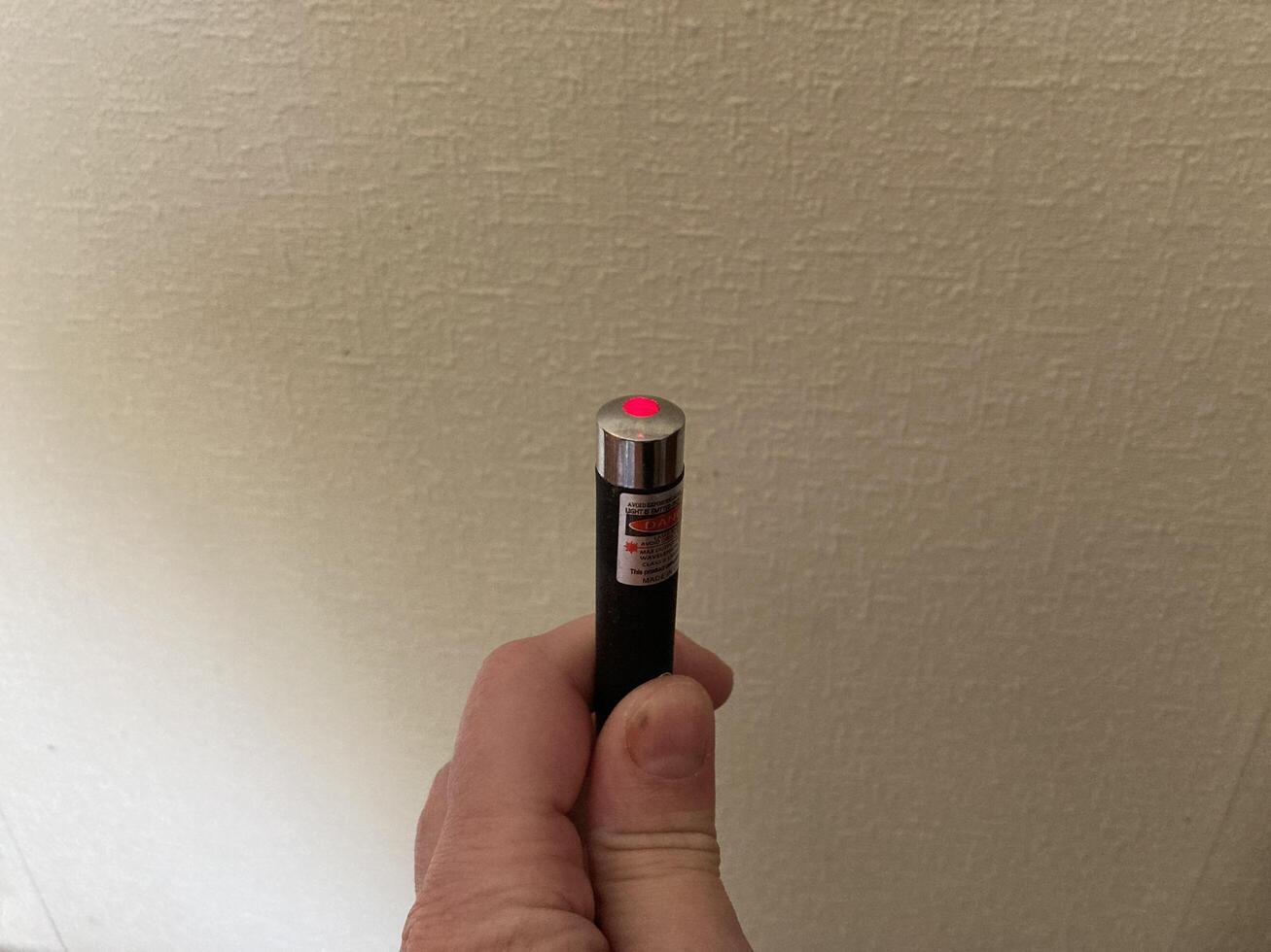 KYIV, UKRAINE - May 8, 2024 Handheld laser pointer shines a beam photo