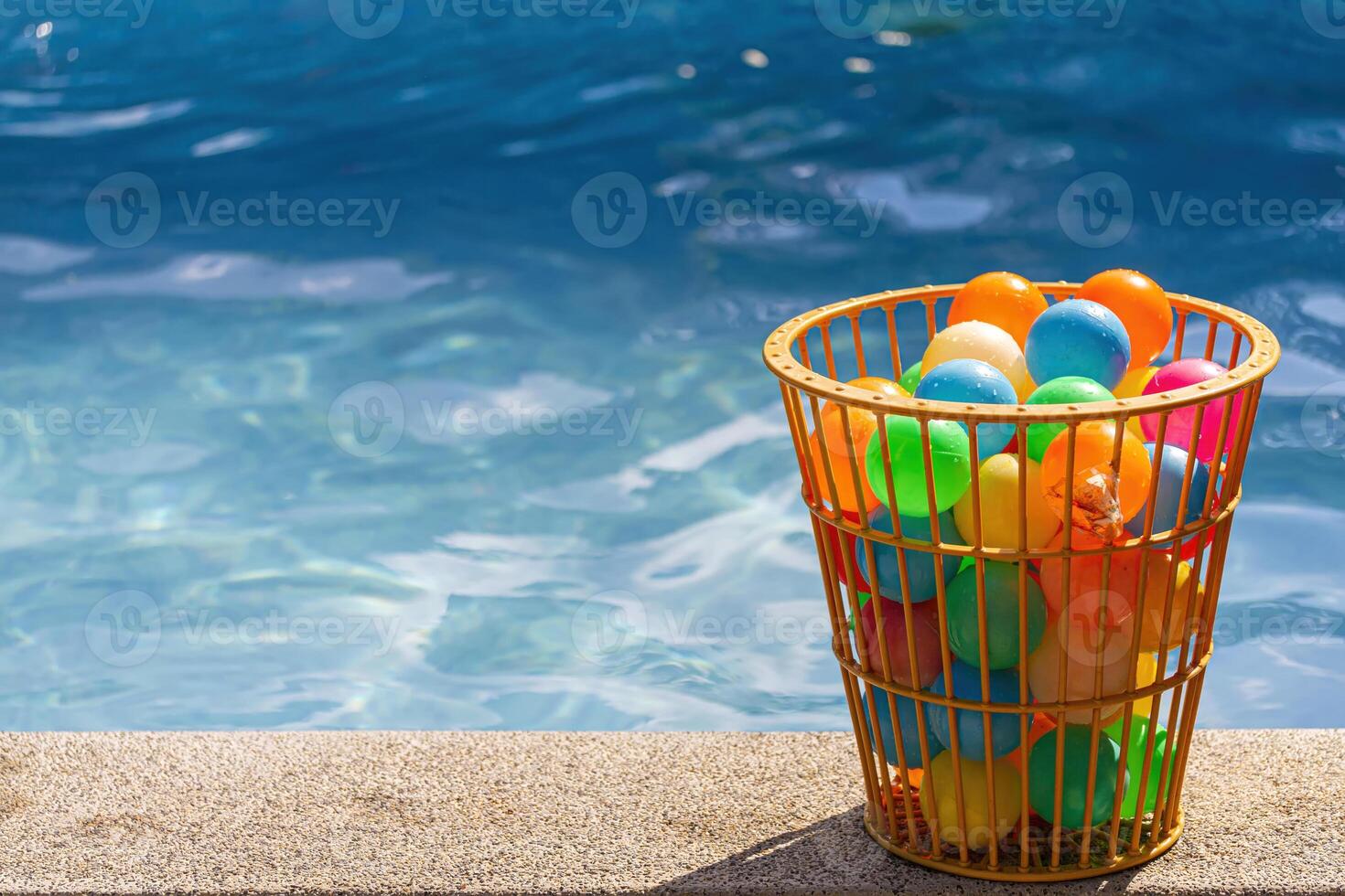 Basket of Colorful Balls by the Pool photo