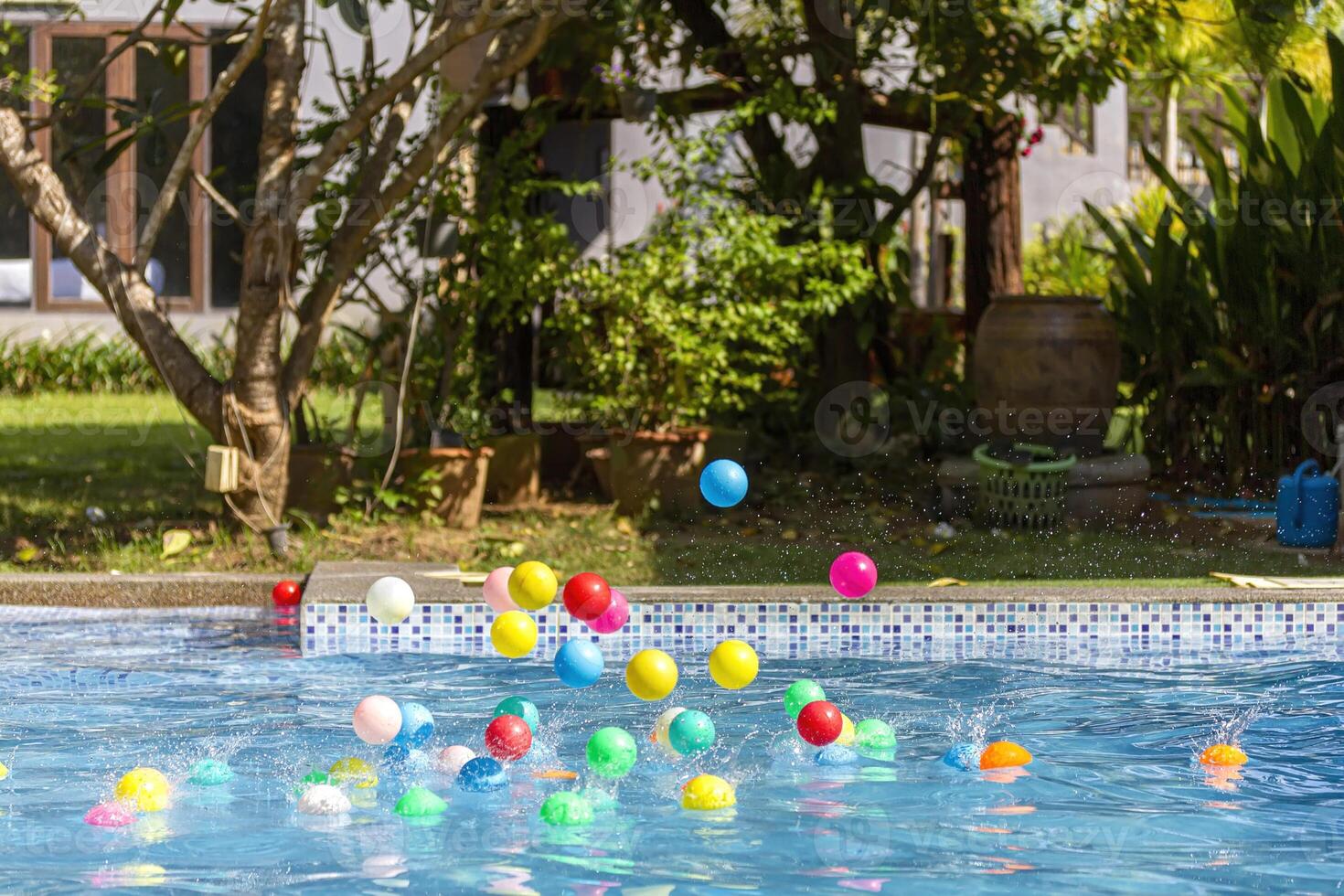 Colorful balls splashing into a pool photo