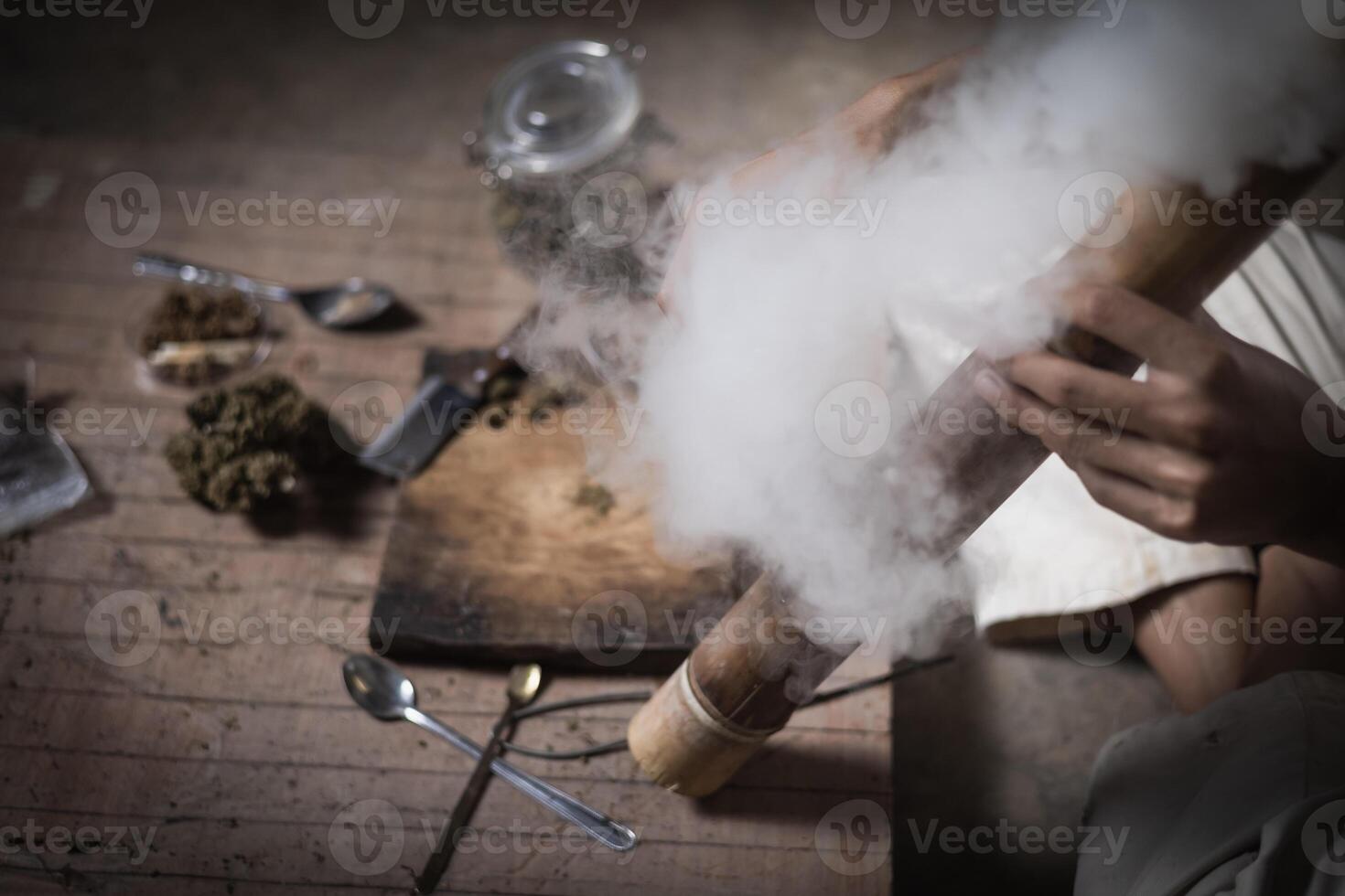 A man prepares marijuana on a cutting board to smoke, person who smokes drugs, drug addict, Drugs addiction and withdrawal symptoms concept. drugsInternational Day against Drug Abuse. photo