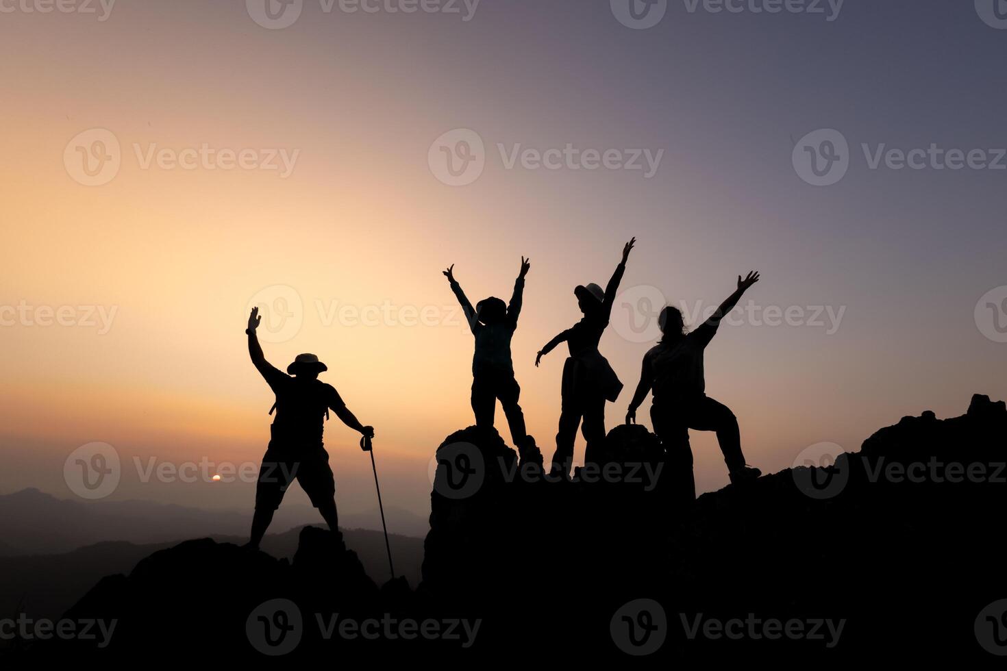 Silhouette of person hikers climbing up mountain cliff and one of them giving helping hand. People success, team work concept. photo