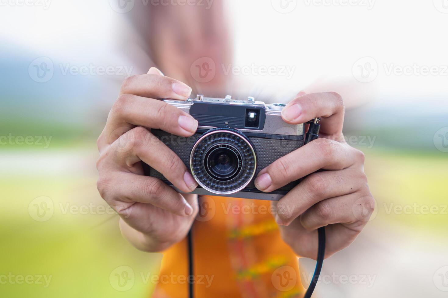 young photographer holds vintage style film camera in her hand and inspects film camera for use after film cameras have become popular with photographers today because of their unique image tones. photo