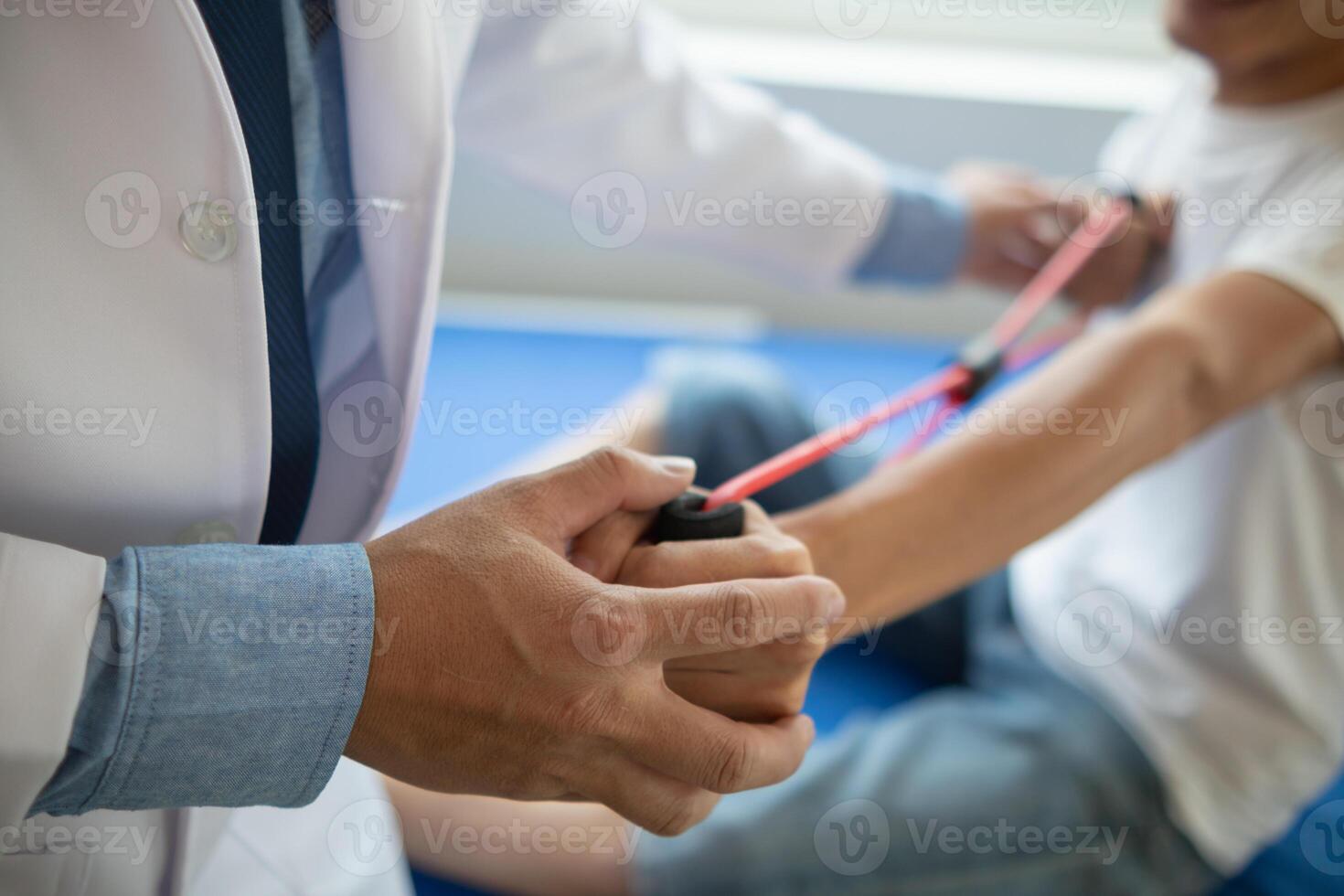 doctor is examining muscle injury and using elastic bands test injury and also help with physical therapy strengthen muscles because physical therapy will help strengthen muscles and help blood flow. photo