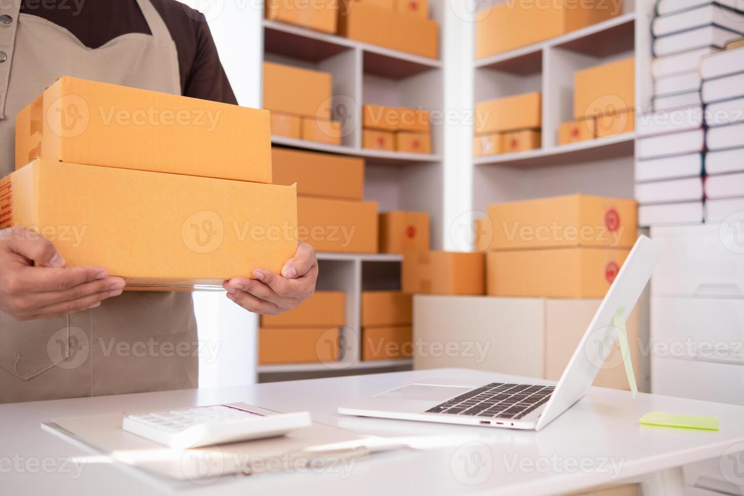 businessman decides invest in small SME business at home by using laptop and smartphone do online marketing and sell things online through an application before packing products according to orders. photo