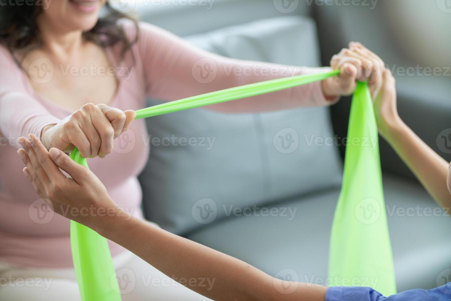 female doctor using elastic bands help patient regain muscle movement after recuperating from muscle injury and wants rehabilitate her be able use her normal daily life by practicing physical therapy photo