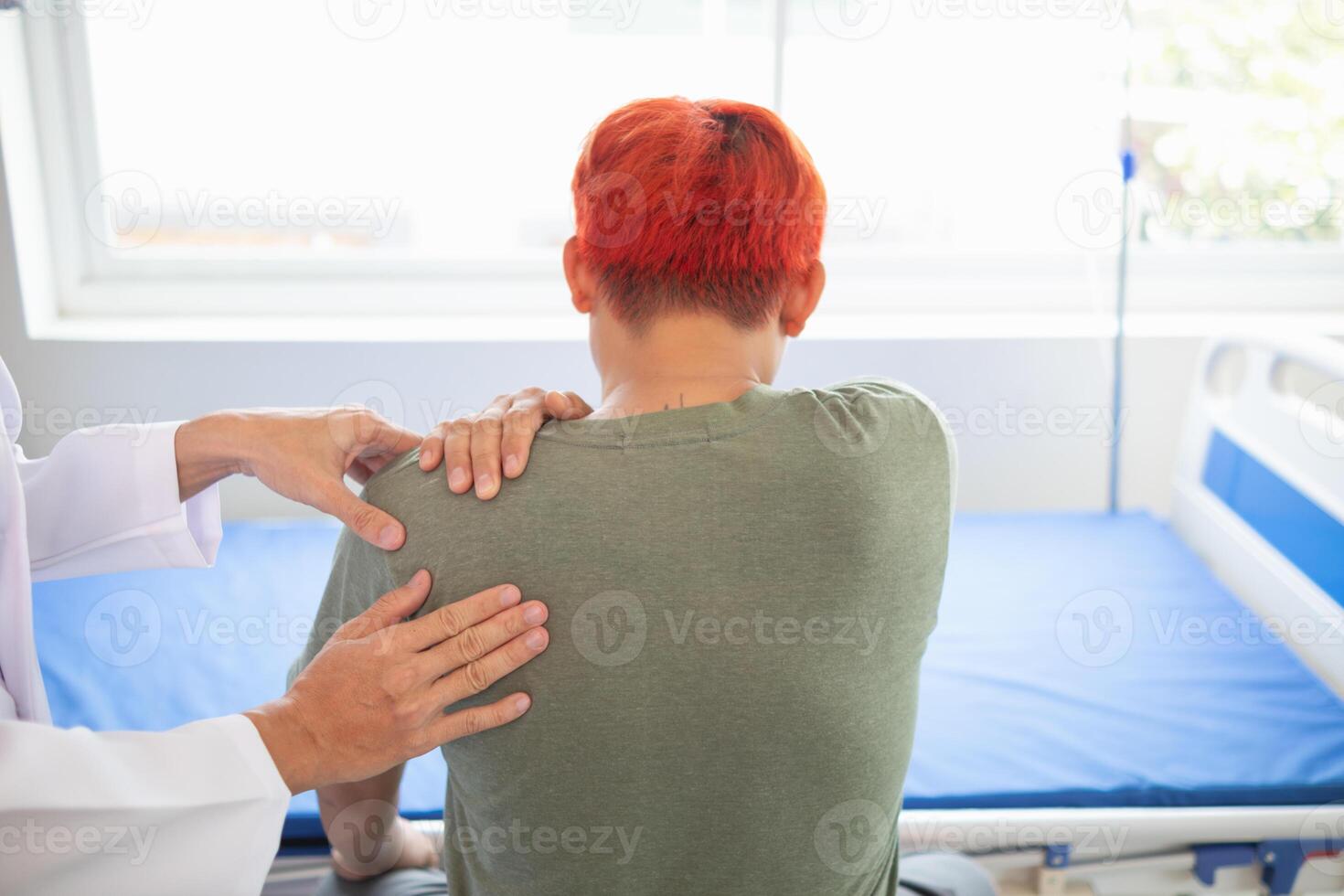 man was admitted for treatment of muscle pain in back of his shoulder due to working hard and causing muscle inflammation. doctor is treating man muscle pain in his back and shoulders due to overwork. photo