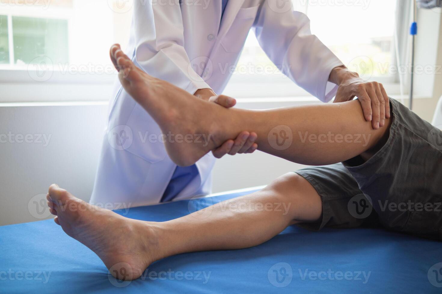 Doctors are examining patient muscle injuries and doing physical therapy for patient to move muscles so they can be used regularly because physical therapy will help strengthen muscles and blood flow. photo