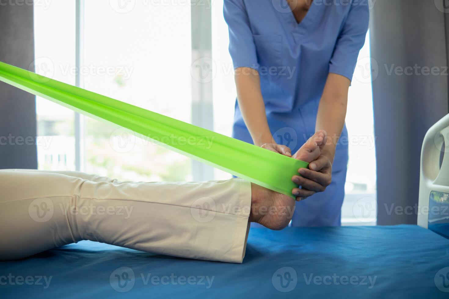 female doctor using elastic bands help patient regain muscle movement after recuperating from muscle injury and wants rehabilitate her be able use her normal daily life by practicing physical therapy photo