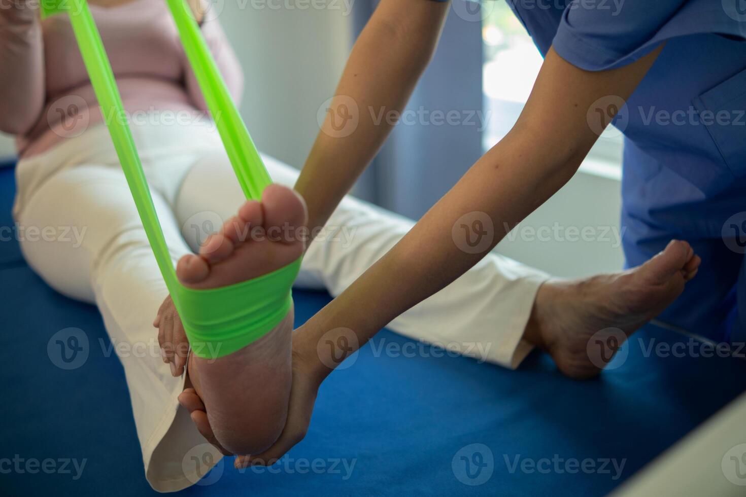 female doctor using elastic bands help patient regain muscle movement after recuperating from muscle injury and wants rehabilitate her be able use her normal daily life by practicing physical therapy photo