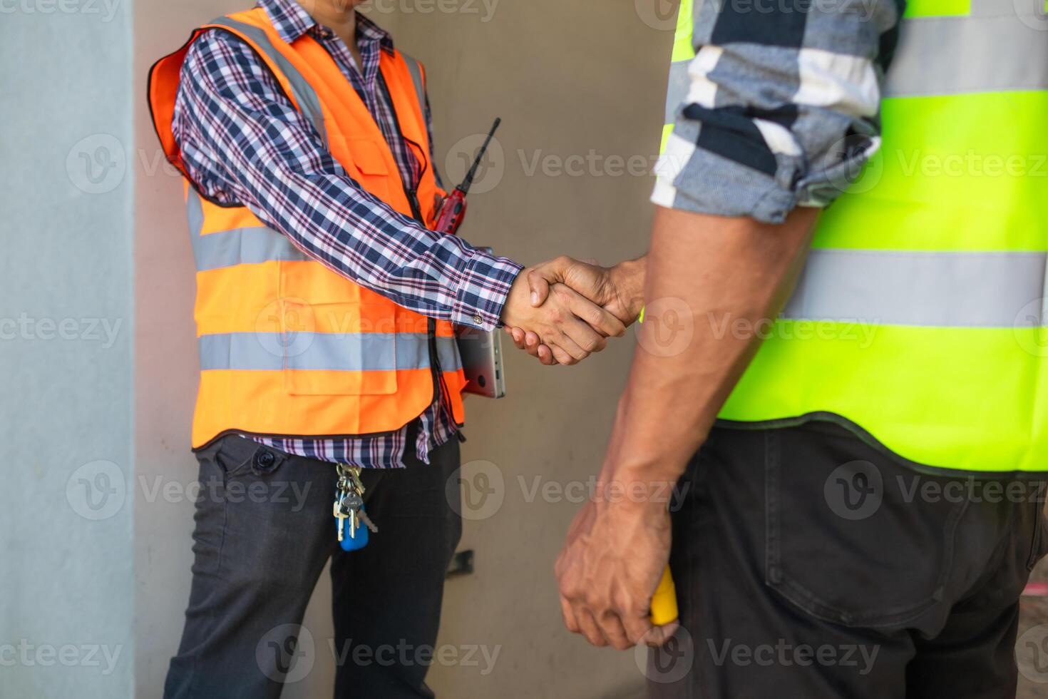 Behind the scenes foreman wearing reflective vest and hard hat inspects construction site to ensure construction meets engineering team's design plans and for the beauty and safety of residents. photo