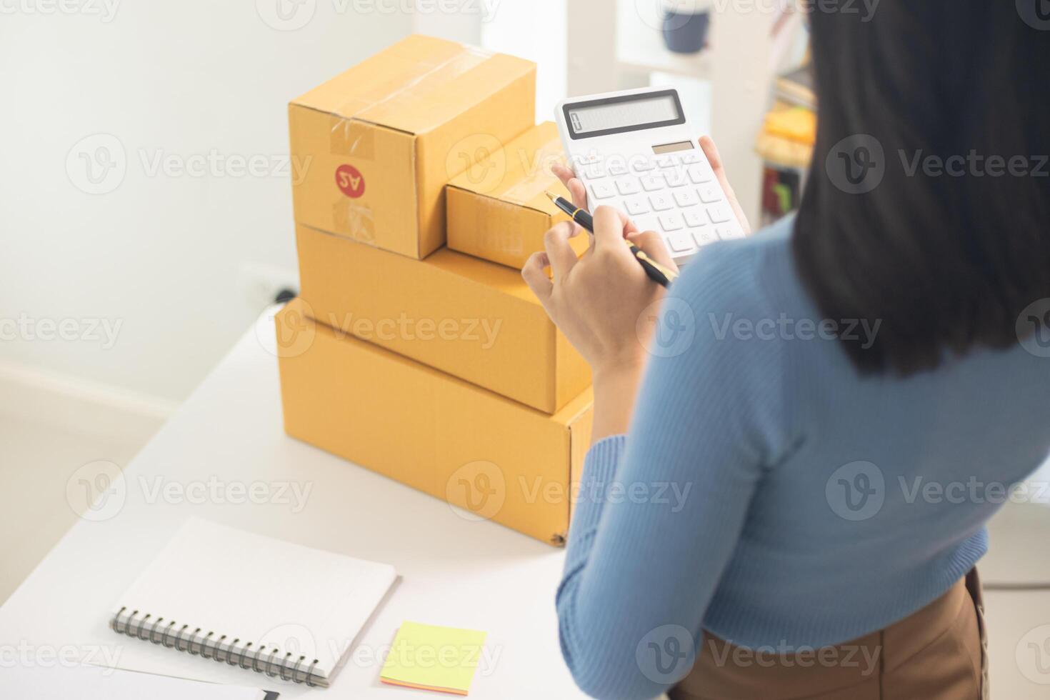 SME business operator is inspecting and packing products into parcel box for delivery company that will come pick up products after participating in online marketing with Application shopping online photo
